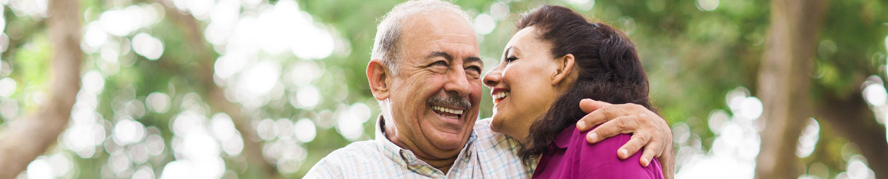 A man and a woman smiling while hugging one another