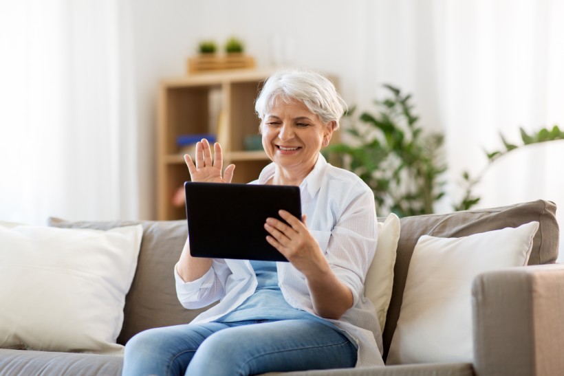 senior woman video chatting her loved ones on a tablet