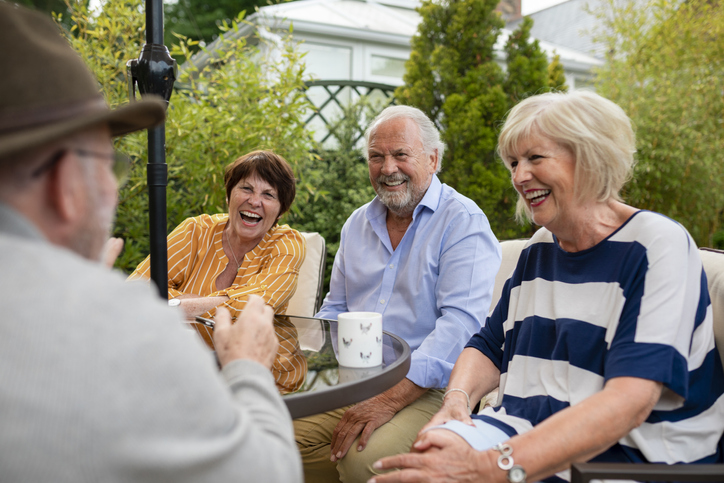 Senior friends sitting in the garden on a summer day together.