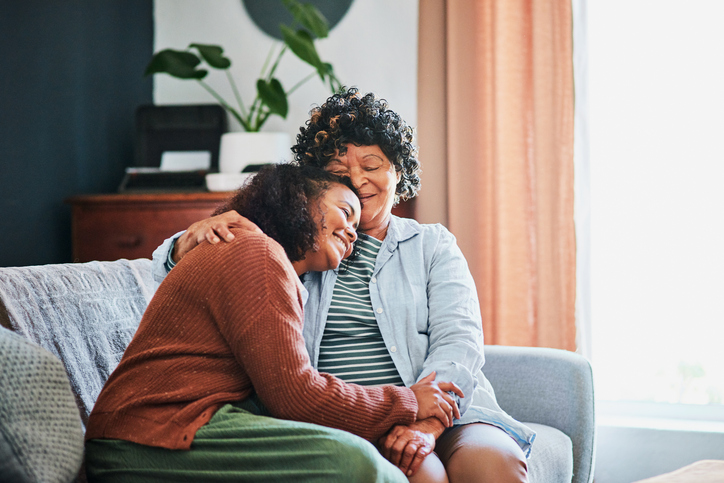 Daughter lovingly hugging her senior mother.