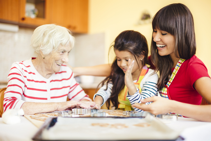 Senior woman baking with adult female and child