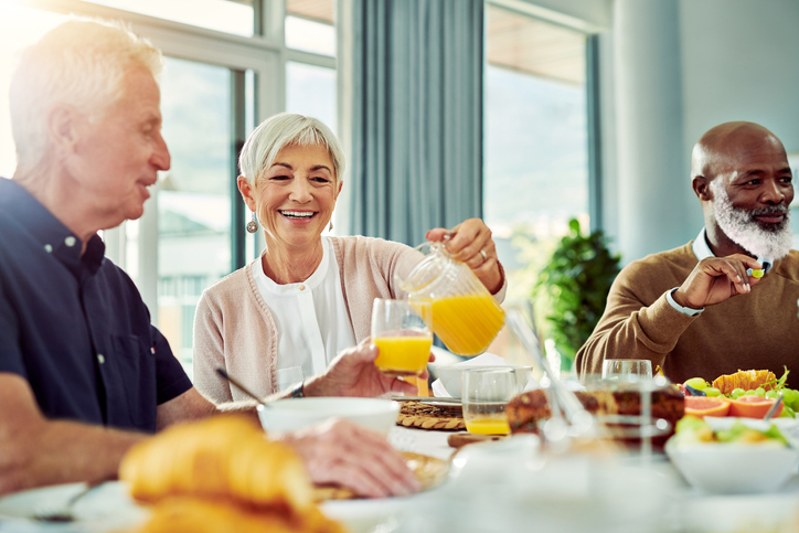 Two senior men and one senior woman enjoying breakfast.